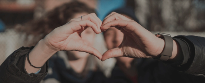 Two people making heart with their hands